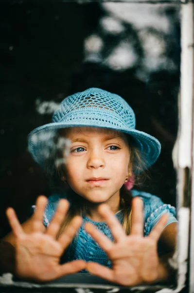 Liten Flicka Blå Stickad Klänning Och Hatt Tittar Genom Fönstret — Stockfoto