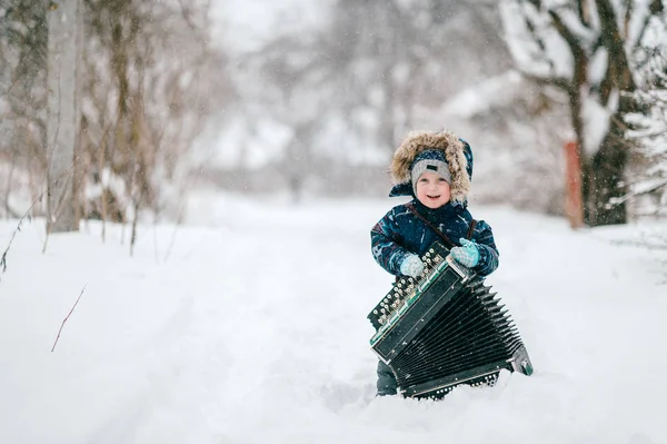 Kaukaski Mały Chłopiec Trzyma Akordeon Zimą Las — Zdjęcie stockowe
