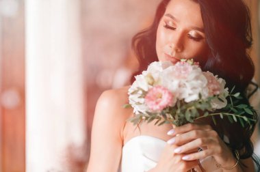 Çiçek buketli beyaz elbiseli güzel gelin 