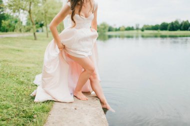 Nehirde ayakta şık gelinlik gelinin kısmi görünümü