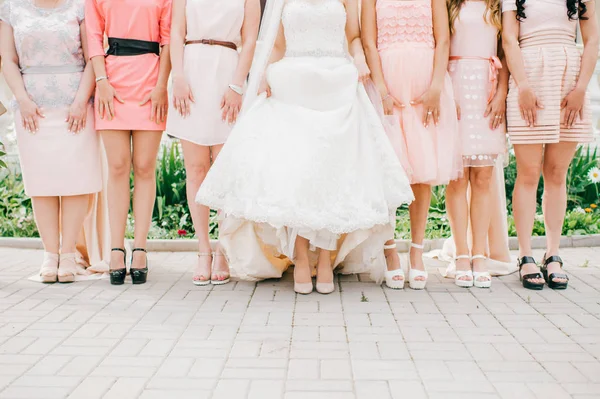 cropped shot of bride and friends standing on street