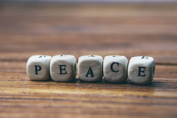 the word peace is written in wooden letters