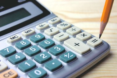 masanın üzerinde hesap makinesiyle kalem