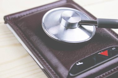 steteskop ve ahşap bir masa üzerinde para