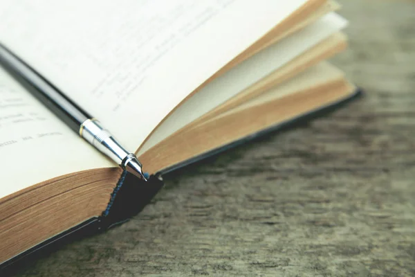 Libro con penna su un tavolo di legno — Foto Stock