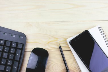 ahşap bir masa üstünde klavye smartphone