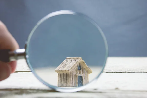 magnifying glass and small house