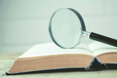 Büyüteç ve masanın üzerine bir kitap