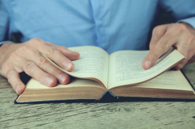 Genç adam kitap okuyor.
