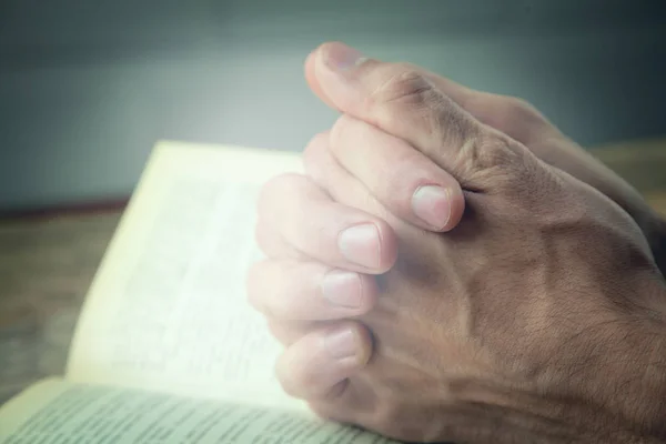 Orando Mãos sobre uma Bíblia Sagrada — Fotografia de Stock