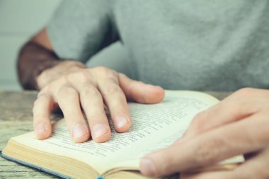 Genç adam kitap okuyor.