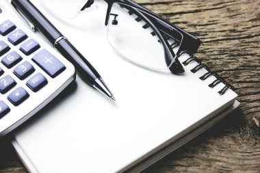 Masanın üzerinde bir not defteri ile hesap makinesi