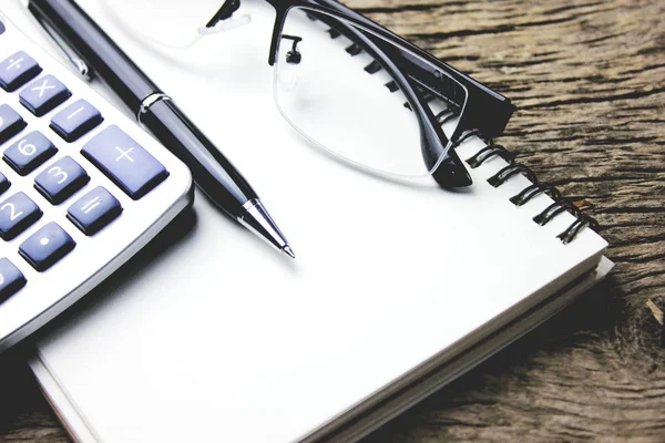 Masanın üzerinde bir not defteri ile hesap makinesi