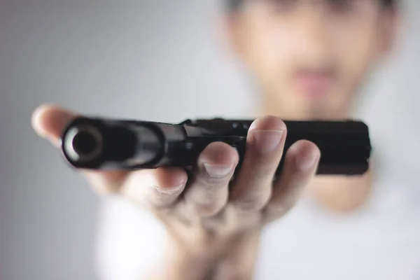 Joven sosteniendo un arma — Foto de Stock