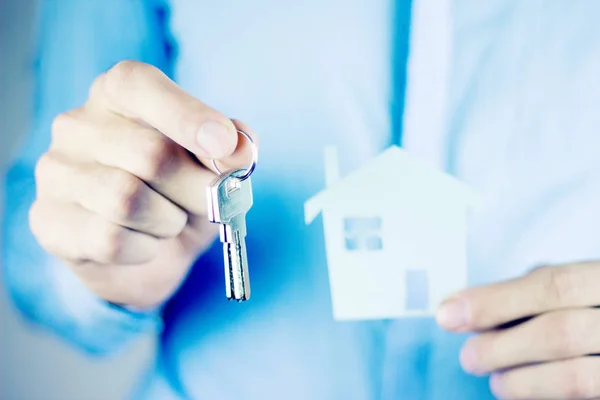 Agent immobilier avec modèle de maison et clés — Photo