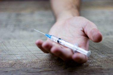 bir şırınga tutan uyuşturucu bağımlısı 