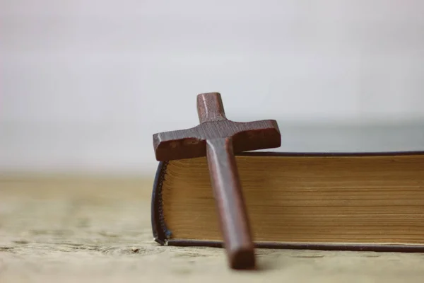 Croce con un libro sul tavolo — Foto Stock