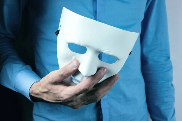 Hombre sostiene máscara en su mano — Foto de Stock