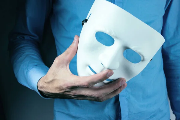Hombre sostiene máscara en su mano — Foto de Stock