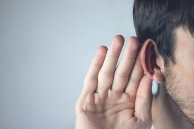 Bir dedikoduyu duymaya çalışan bir iş adamı.