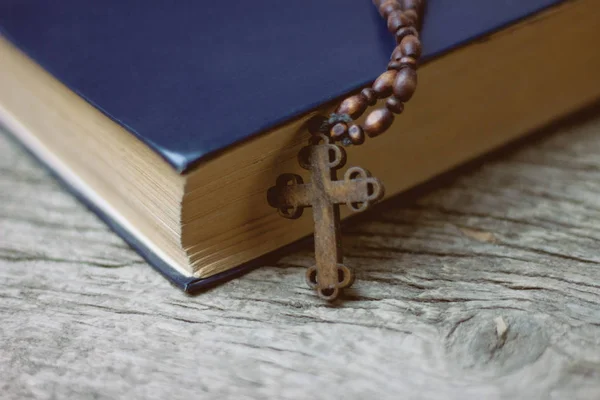 Croce con un libro sul tavolo — Foto Stock