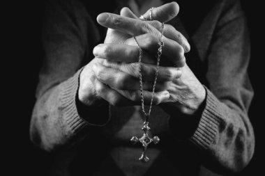 Yaşlı bir kadının elleri haç tutan