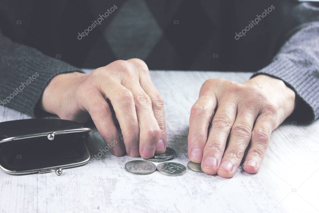 Senior woman counting coins 