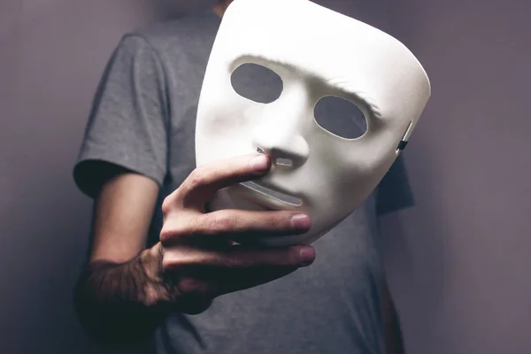 Homem segura máscara em sua mão — Fotografia de Stock