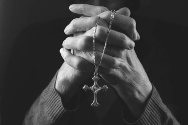 Yaşlı bir kadının elleri haç tutan