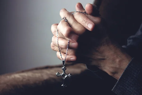 Mãos de uma velha segurando uma cruz — Fotografia de Stock