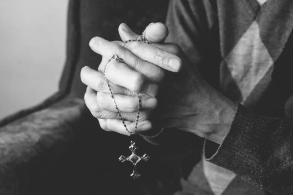 Mãos de uma velha segurando uma cruz — Fotografia de Stock