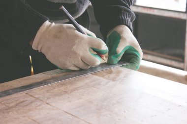 Adam fayansı kurşun kalemle işaretliyor.