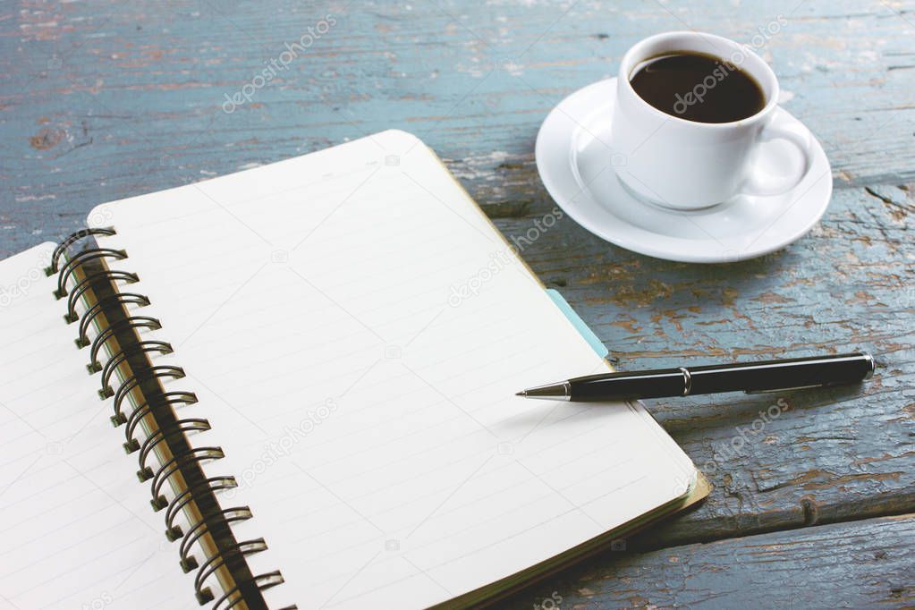 coffee with a notebook and pens on the table