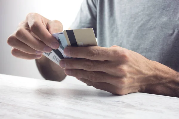 Egy fiatalember feltart néhány hitelkártyát. — Stock Fotó