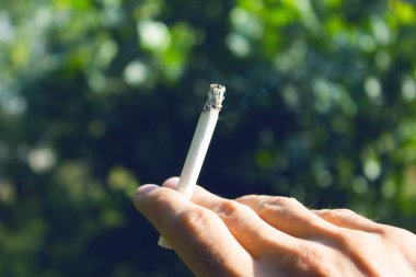 Elinde sigara tutan genç adam.