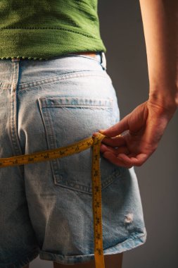 Belini ölçen bir kadının yakın çekimi. 