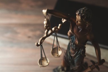 Adalet heykeli ve adalet terazisi siyah arka planda..