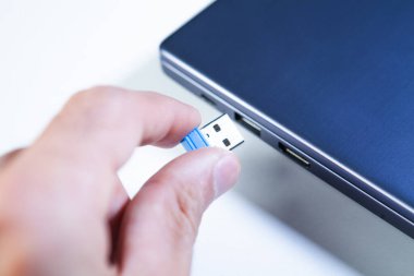 Dizüstü bilgisayarda USB flaş bellek tutan bir eli kapat