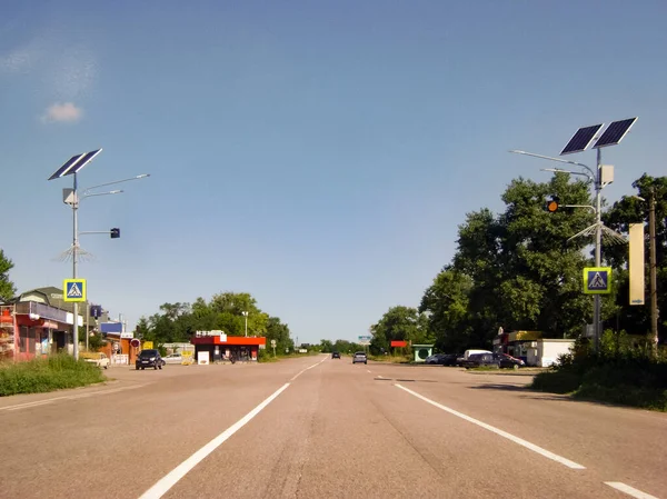 Banliyö otobanının trafik ışıklarında güneş panelleri. Sağda görünür sarı bir ışık var. Rayların üzerinde de araba fren izleri var..