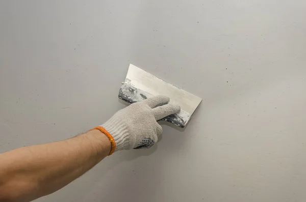 Trabajar paredes de masilla. La alineación de las paredes con una paleta — Foto de Stock