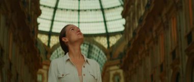 Kadın tarihi alışveriş galerisinin içindeki kubbeli cam tavana bakıyor..