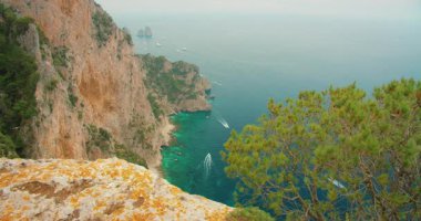 Güneşli bir yaz gününde İtalya 'nın Capri kıyısındaki Faraglioni kayalıklarında tekne gezintisi.