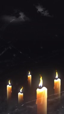 Four candles burning brightly in a dark setting, suggesting peace or remembrance.