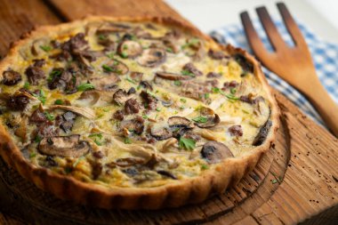 Tahta bir masada yabani mantarlı kiş, yumurta ve sığır eti..