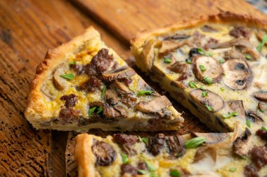 Tahta bir masada yabani mantarlı kiş, yumurta ve sığır eti..