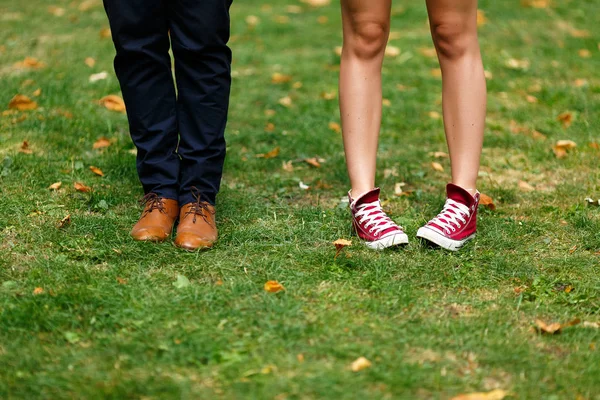 Mädchen in roten Turnschuhen und ein Mann in braunen Schuhen. — Stockfoto