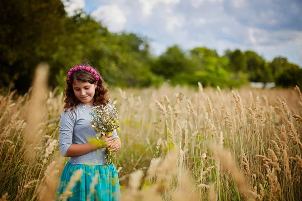 Liten flicka på ett vete fält i solljus — Stockfoto