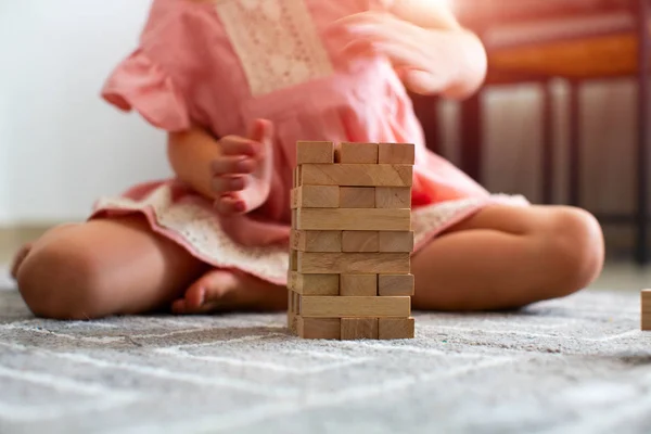Mooi meisje speelt met de houten spel. op witte achtergrond. — Stockfoto