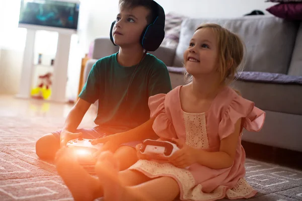 Close-up broers en zussen met afspelen van video game op tapijt thuis-controllers — Stockfoto