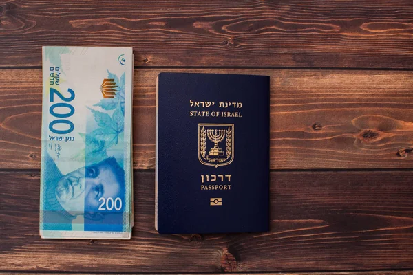 İsrail para faturaları 200 şekel ve İsrail pasaportu yığını.